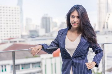 Fototapeta premium Business woman with office building background.