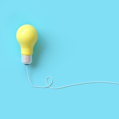 Yellow lightbulb with wire on blue background for copyspace. minimal idea concept. top view