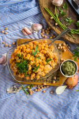 Indian chickpea salad with grated carrot, onion, garlic paste, tahini sesame seeds paste and fresh green herbs. Vegan, vegetarian healthy food.