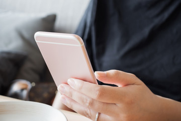 Woman with diamond ring on hand using smartphone in cafe restaurant