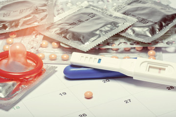 condom with contraceptive on calendar background, close up birth control pill on calendar, health care and medicine concept
