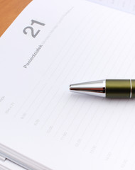 Pen lying on calendar or organizer on desk in office