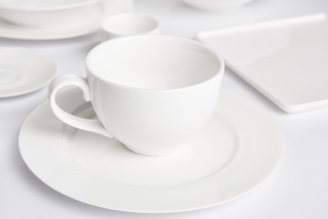 Fototapeta na wymiar selective focus of plates and bowl on white tabletop
