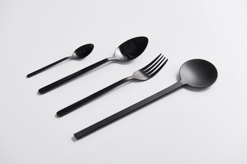 close up image of arranged salad spoon, fork and spoons on white table