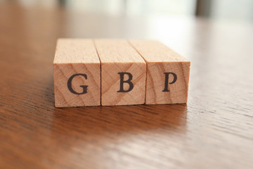 GBP (Great Britain Pound) Text Block on Wooden Table