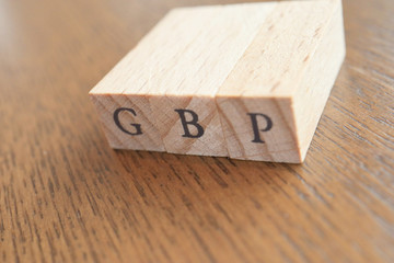 GBP (Great Britain Pound) Text Block on Wooden Table