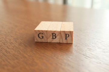GBP (Great Britain Pound) Text Block on Wooden Table