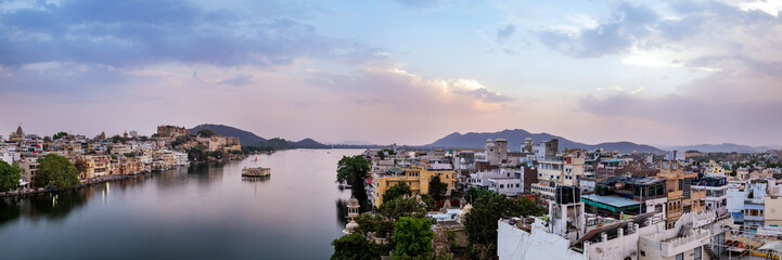 Fototapeta premium Udaipur city at lake Pichola in the evening, Rajasthan, India. View of City palace reflected on the lake.
