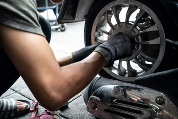 The Motorcycle change tire by Man repairer at Bangkok Thailand.