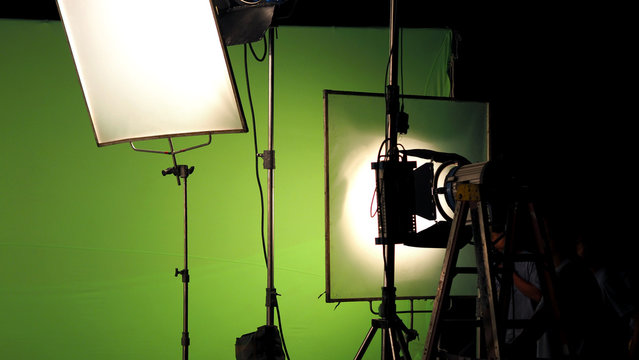 Big studio lighting kit 5000 watt with soft box on tripod and professional green screen background chroma key post production technique shooting or filming for movie or video commercial set up.