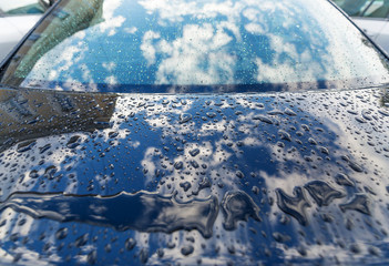 Raindrops on a car surface.