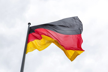 The national flag of the Federal Republic of Germany has evolved in the wind against the sky