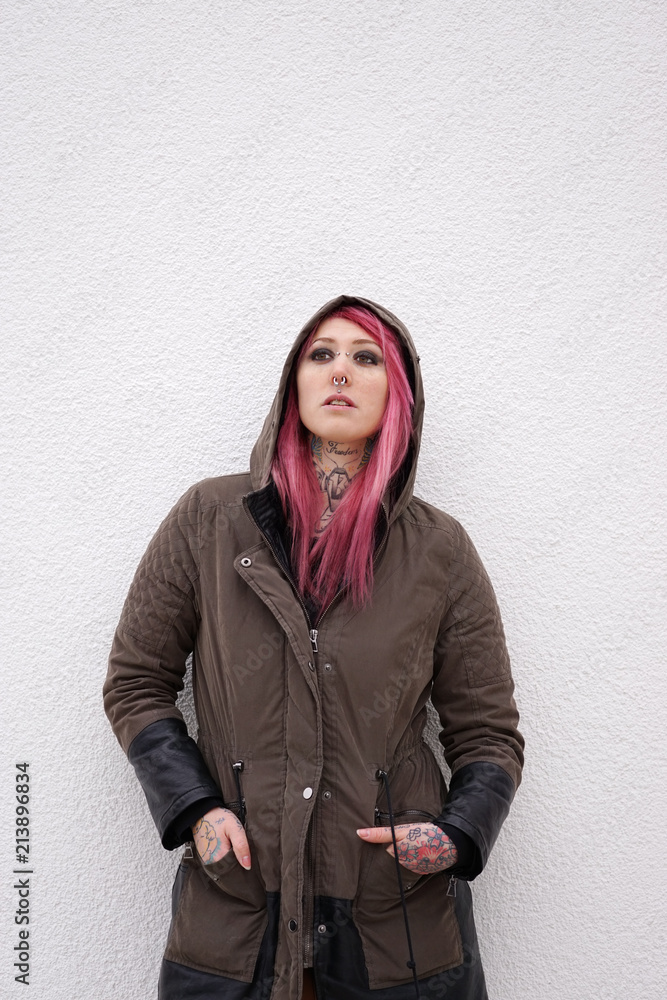 Wall mural young alternative woman with pink hair piercings and tattoos