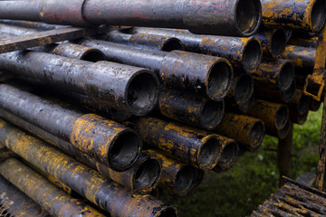 Oil Drill pipe. Rusty drill pipes were drilled in the well section. Downhole drilling rig. Laying the pipe on the deck. View of the shell of drill pipes laid in courtyard of the oil and gas warehouse.