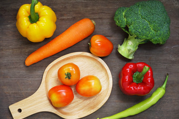 Topview raw vegetables,carrot and tometos and carot and green chilli and bell peper on wood table