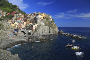 Fototapeta na wymiar Colorful village of Manarola with fisher boats on the foreground, Cinque Terre, Italy