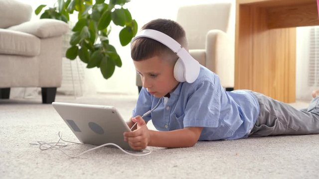 Small boy in headphones using tablet