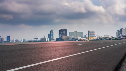 Fototapeta na wymiar Empty road asphalt with panoramic cityscape