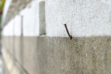 Rusty nails mounted on a two-color stone wall