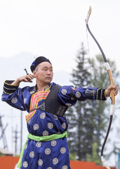 Young man shoots from a sports bow