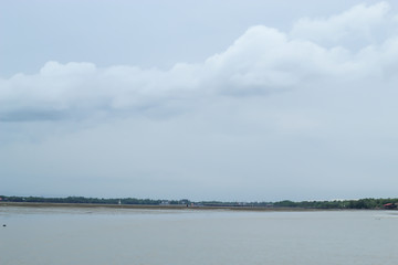 Natural forest and sky at Don Hoi lot in Women looking for Snail shells on the sea floor mud at Don Hoi lot in Samut songkham , Thailand..