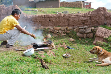 Native american man cooking the meat in the countryside.