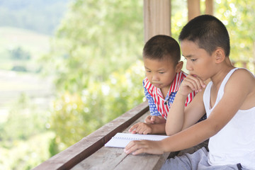 Two children sit reading books searching for knowledge, Educational concepts