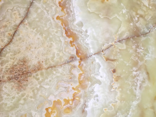 Beige marble in a cut close-up with white impregnations.