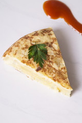traditional spanish omelette dish with tomato sauce