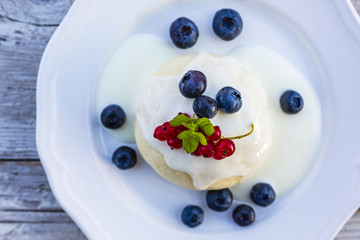 A delicious dessert with steamed dumpling and freshly picked fruits on a wooden table.