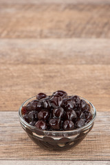 Tapioca Pearl , Bubble topping for tea or other beverage, in a cup, place on wooden table. Copy space