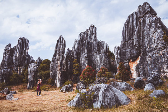 Woman tourist in stone forest, rock formations in Yunnan, China