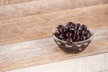 Tapioca Pearl , Bubble topping for tea or other beverage, in a cup, place on wooden table. Copy space