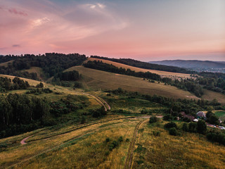 Naklejka premium Field in farm is sown with barley, buckwheat, wheat, plowed land for planting crop. Aerial photography, top view. sunset