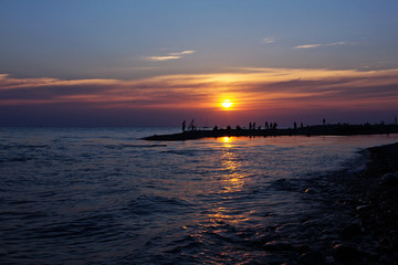 Large crowds of tourists on the black sea in the summer evening.