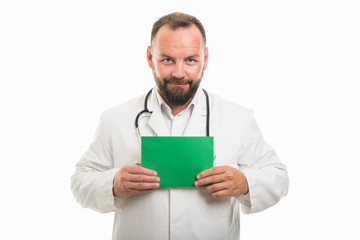 Portrait of male doctor holding green cardboard