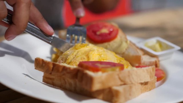 Cut with a knife and fork omelette on a plate with toast. 3840x2160. 4k