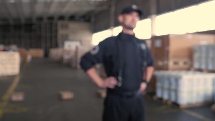 anonymous Polish customs officer talks on the backyard of warehouse