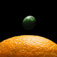 View of Earth from the moon surface. Watermelon and orange background. Abstract space fruit concept.
