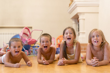 The group of four children lying on the floor. Four happy children lie on the floor.