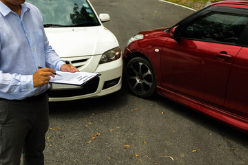 The insurance agent examining car after accident on the road. Insurance claim concept .