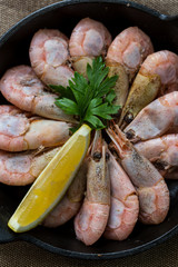 plate of boiled prawns on dark table, top view. Close up