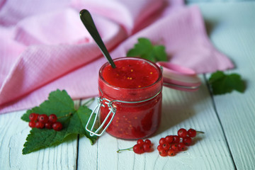 A glass jar of red currant jam.