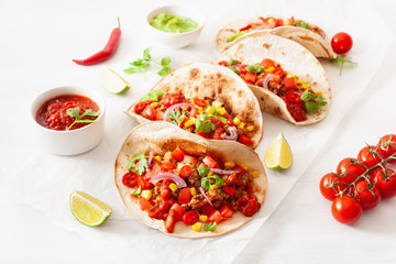 mexican beef and pork tacos with salsa, guacamole and vegetables