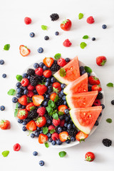 fruit and berry platter over white. blueberry, strawberry, raspberry, blackberry, watermelon