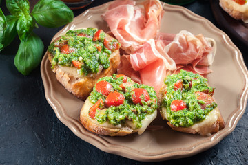 Bruschetta with fresh pesto, mozzarella and cherry tomatoes on a plate