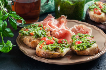 Bruschetta with fresh pesto, mozzarella and cherry tomatoes on a plate