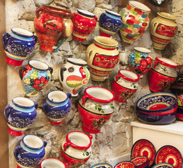 Handmade cups made of clay covered by paint.close-up of various utensils painted in the style of souvenir shop Besalu, Spain