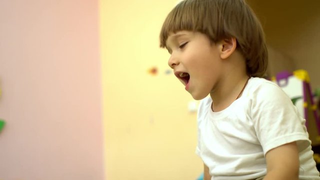 Cute preschool toddler sing a song in nursery school
