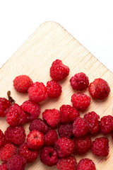 Forest raspberry on a wooden board, top view.
